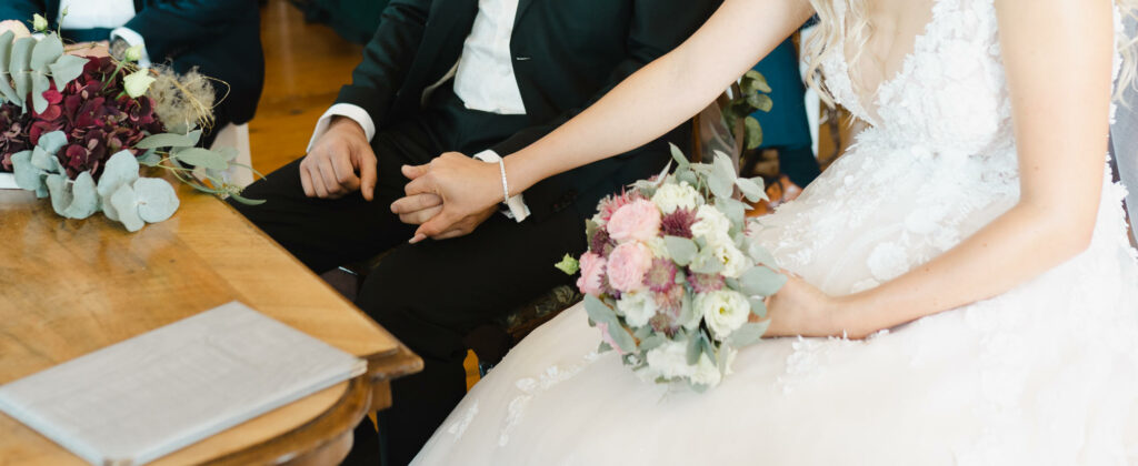Close up der Hände eines Hochzeitspaares während der Trauung im Kloster Holzen